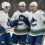 
              Vancouver Canucks centre J.T. Miller (9) is congratulated on his goal against the Toronto Maple Leafs by teammates Travis Hamonic (27) and Tanner Pearson (70) during the first period of an NHL hockey game Saturday, March 5, 2022, in Toronto. (Frank Gunn/The Canadian Press via AP)
            