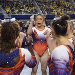 
              Auburn gymnast Sunisa Lee gathers with teammates before performing at a meet at the University of Michigan, Saturday, March 12, 2022, in Ann Arbor, Mich. A record crowd came out to watch Lee, the reigning Olympic champion, and Auburn take on defending national champion Michigan. The arrival of Lee and several of her Olympic teammates at the collegiate level is helping fuel a spike in interest and participation in NCAA women's gymnastics. (AP Photo/Carlos Osorio)
            