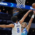 
              Charlotte Hornets guard Kelly Oubre Jr. (12) shoots over Dallas Mavericks guard Josh Green (8) during the first half of an NBA basketball game Saturday, March 19, 2022, in Charlotte, N.C. (AP Photo/Rusty Jones)
            