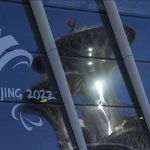 
              The Beijing Olympic Tower is reflected on the window panels of the Main Media Center displaying the logo of the 2022 Winter Paralympics in Beijing, China, Wednesday, March 2, 2022. Russian and Belarusian athletes at the Winter Paralympic Games in Beijing will compete as “neutrals,” but will not be expelled because of their countries' roles in the war against Ukraine, the International Paralympic Committee said Wednesday. (AP Photo/Andy Wong)
            