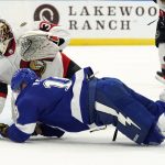
              Tampa Bay Lightning left wing Ondrej Palat (18) gets knocked down after getting off a shot on Ottawa Senators goaltender Matt Murray (30) during the second period of an NHL hockey game Tuesday, March 1, 2022, in Tampa, Fla. (AP Photo/Chris O'Meara)
            