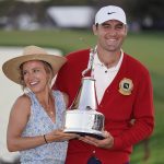 
              Scottie Scheffler, right, celebrates with his wife Meredith as they hold the championship trophy after he won the Arnold Palmer Invitational golf tournament Sunday, March 6, 2022, in Orlando, Fla. (AP Photo/John Raoux)
            