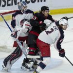 
              Columbus Blue Jackets defenseman Andrew Peeke pushes Ottawa Senators right wing Tyler Ennis into Blue Jackets goaltender Elvis Merzlikins during the first period of an NHL hockey game Wednesday, March 16, 2022 in Ottawa, Ontario.(Adrian Wyld/The Canadian Press via AP)
            