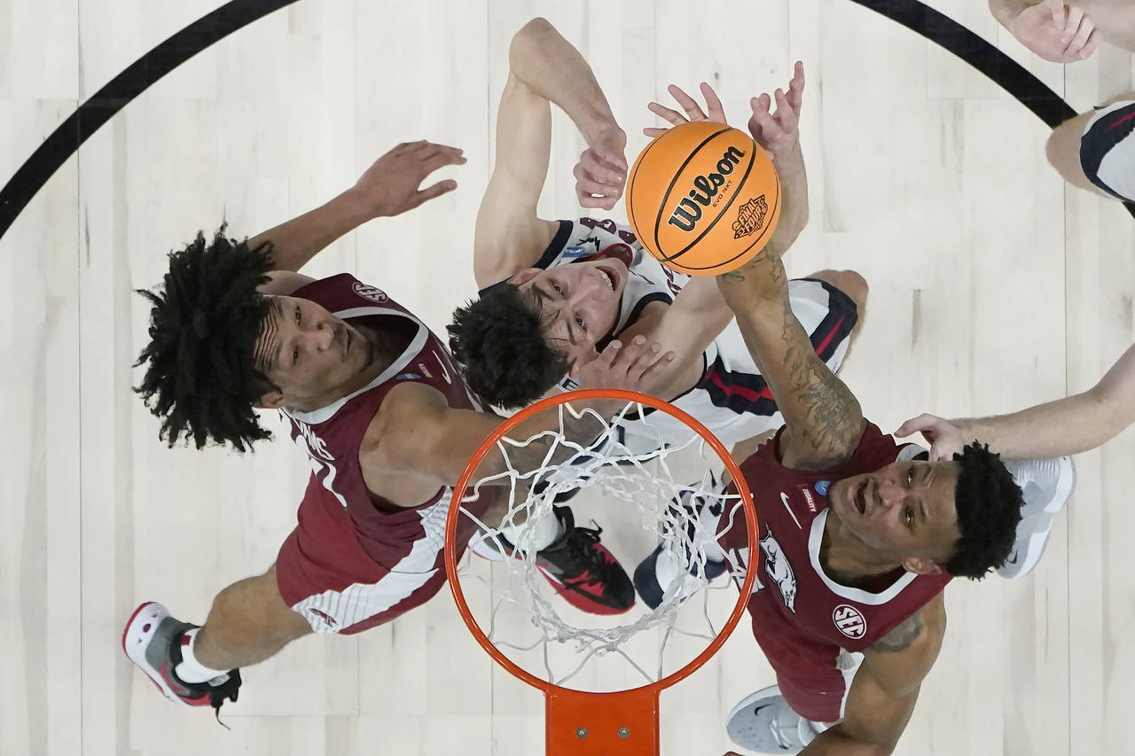 Arkansas guard Au'Diese Toney, right, scores over Gonzaga center Chet Holmgren, middle, during the ...