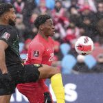 
              Canada's Jonathan David, right, and Jamaica's Adrian Mariappa vie for the ball during first-half CONCACAF World Cup soccer qualifying match in Toronto, Sunday, March 27, 2022. (Nathan Denette/The Canadian Press via AP)
            