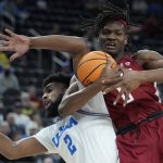 
              UCLA's Cody Riley, left, and Washington State's Efe Abogidi (0) battle for the ball during the first half of an NCAA college basketball game in the quarterfinal round of the Pac-12 tournament Thursday, March 10, 2022, in Las Vegas. (AP Photo/John Locher)
            