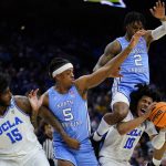 
              North Carolina's Caleb Love (2) collides with UCLA's Tyger Campbell (10) as Armando Bacot (5) and Myles Johnson (15) look on during the first half of a college basketball game in the Sweet 16 round of the NCAA tournament, Friday, March 25, 2022, in Philadelphia. (AP Photo/Matt Rourke)
            