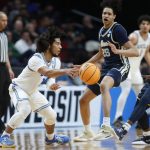 
              UCLA guard Tyger Campbell, left, passes around Akron guard Garvin Clarke, right, and forward Enrique Freeman (25) during the second half of a first-round NCAA college basketball tournament game, Thursday, March 17, 2022, in Portland, Ore. (AP Photo/Craig Mitchelldyer)
            