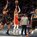 
              Atlanta Hawks guard Trae Young (11) shoots over New York Knicks guard Alec Burks (18) as Knicks guard Evan Fournier (13) looks on during the first half of an NBA basketball game, Tuesday, March 22, 2022, in New York. (AP Photo/Jessie Alcheh)
            