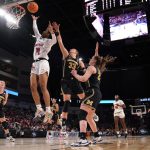 
              Louisville guard Kianna Smith (14) drives against Michigan forward Emily Kiser (33) during the first half of a college basketball game in the Elite 8 round of the NCAA women's tournament Monday, March 28, 2022, in Wichita, Kan. (AP Photo/Jeff Roberson)
            