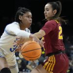 
              UCLA's Camryn Brown (35) passes around Southern California's Alyson Miura (25) during the first half of an NCAA college basketball game in the first round of the Pac-12 women's tournament Wednesday, March 2, 2022, in Las Vegas. (AP Photo/John Locher)
            