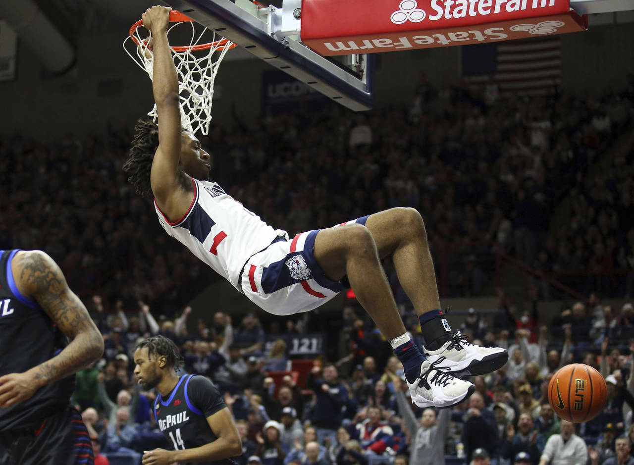 Connecticut's Isaiah Whaley (5) slam dunks the ball during the first half of an NCAA college basket...