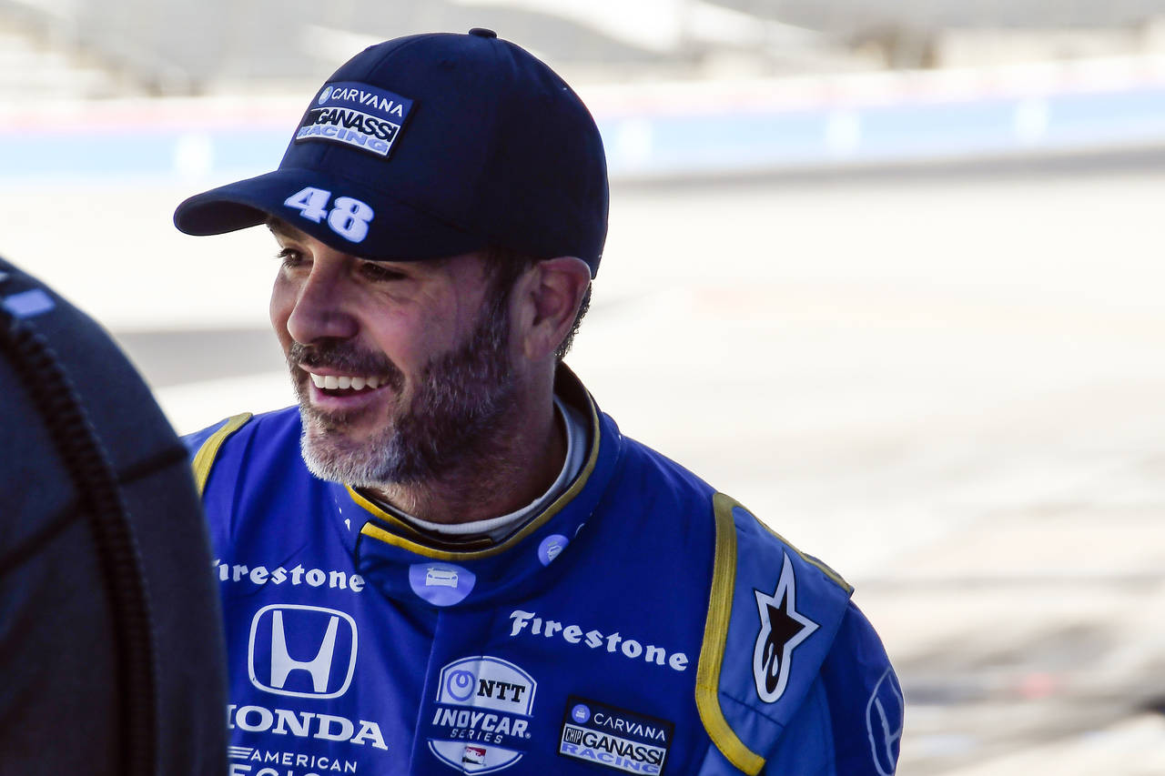 Jimmie Johnson smiles after finishing the first practice round of the IndyCar Series auto race at T...