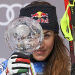 
              Italy's Sofia Goggia celebrates with the women's downhill overall leader cup, on the podium of an alpine ski, women's World Cup Finals downhill, in Courchevel, France, Wednesday, March 16, 2022. (AP Photo/Alessandro Trovati)
            