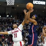 
              Connecticut guard Christyn Williams (13) puts up a shot against NC State forward Jakia Brown-Turner (11) and forward Kayla Jones (25) during the first quarter of the East Regional final college basketball game of the NCAA women's tournament, Monday, March 28, 2022, in Bridgeport, Conn. (AP Photo/Frank Franklin II)
            
