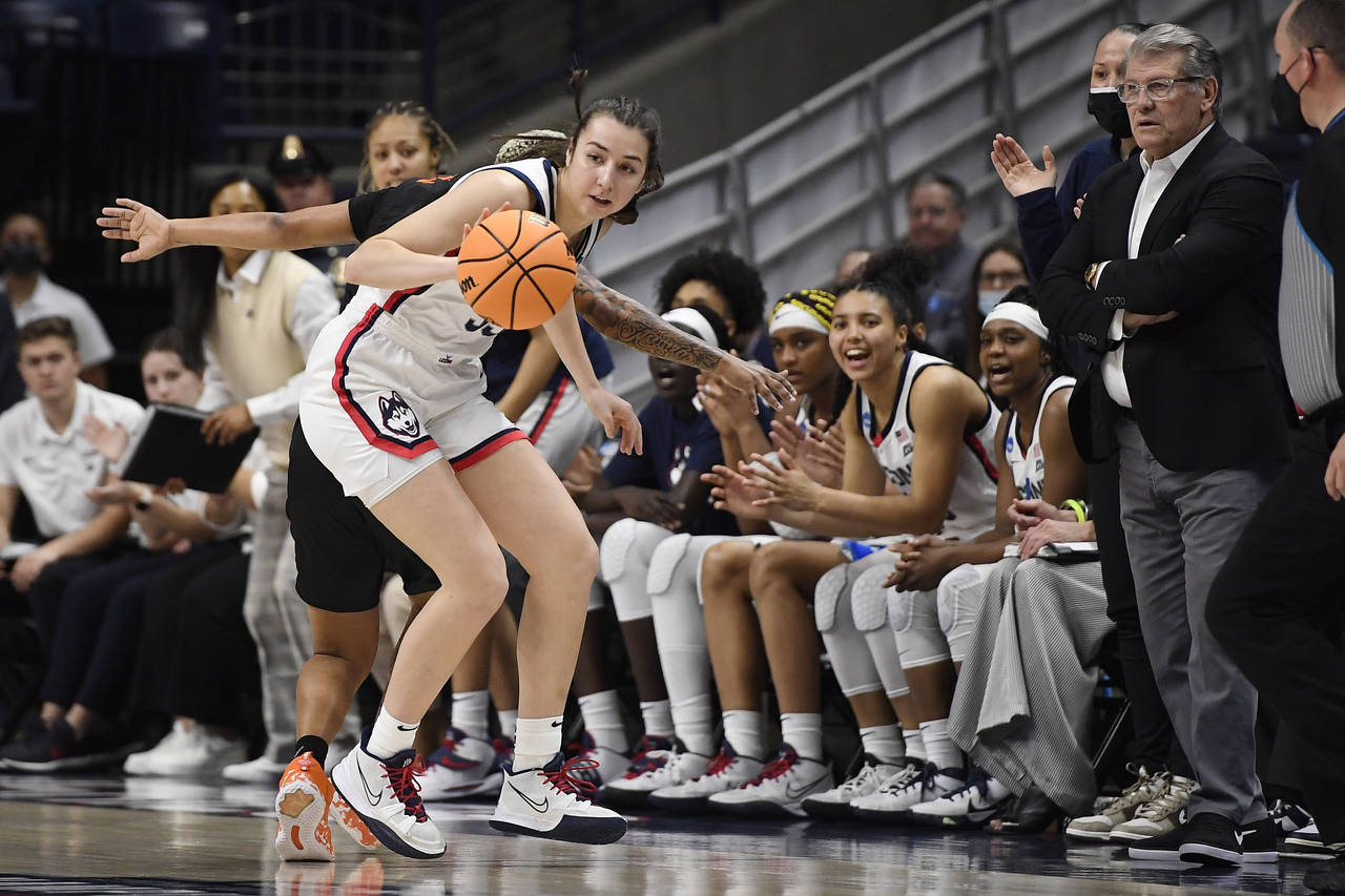 Connecticut's Caroline Ducharme, left, steals the ball from Mercer's Endia Banks as her team and Co...