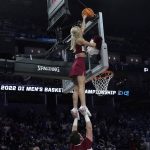 
              An Arkansas cheerleader reaches for a ball stuck on the top of the glass during the second half of a college basketball game between Duke and Arkansas in the Elite 8 round of the NCAA men's tournament in San Francisco, Saturday, March 26, 2022. (AP Photo/Marcio Jose Sanchez)
            