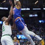
              Golden State Warriors forward Jonathan Kuminga, top, dunks against Boston Celtics center Al Horford during the first half of an NBA basketball game in San Francisco, Wednesday, March 16, 2022. (AP Photo/Jeff Chiu)
            