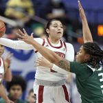
              North Carolina State guard Raina Perez passes around Miami forward Destiny Harden (3) during the first half of NCAA college basketball championship game at the Atlantic Coast Conference women's tournament in Greensboro, N.C., Sunday, March 6, 2022. (AP Photo/Gerry Broome)
            