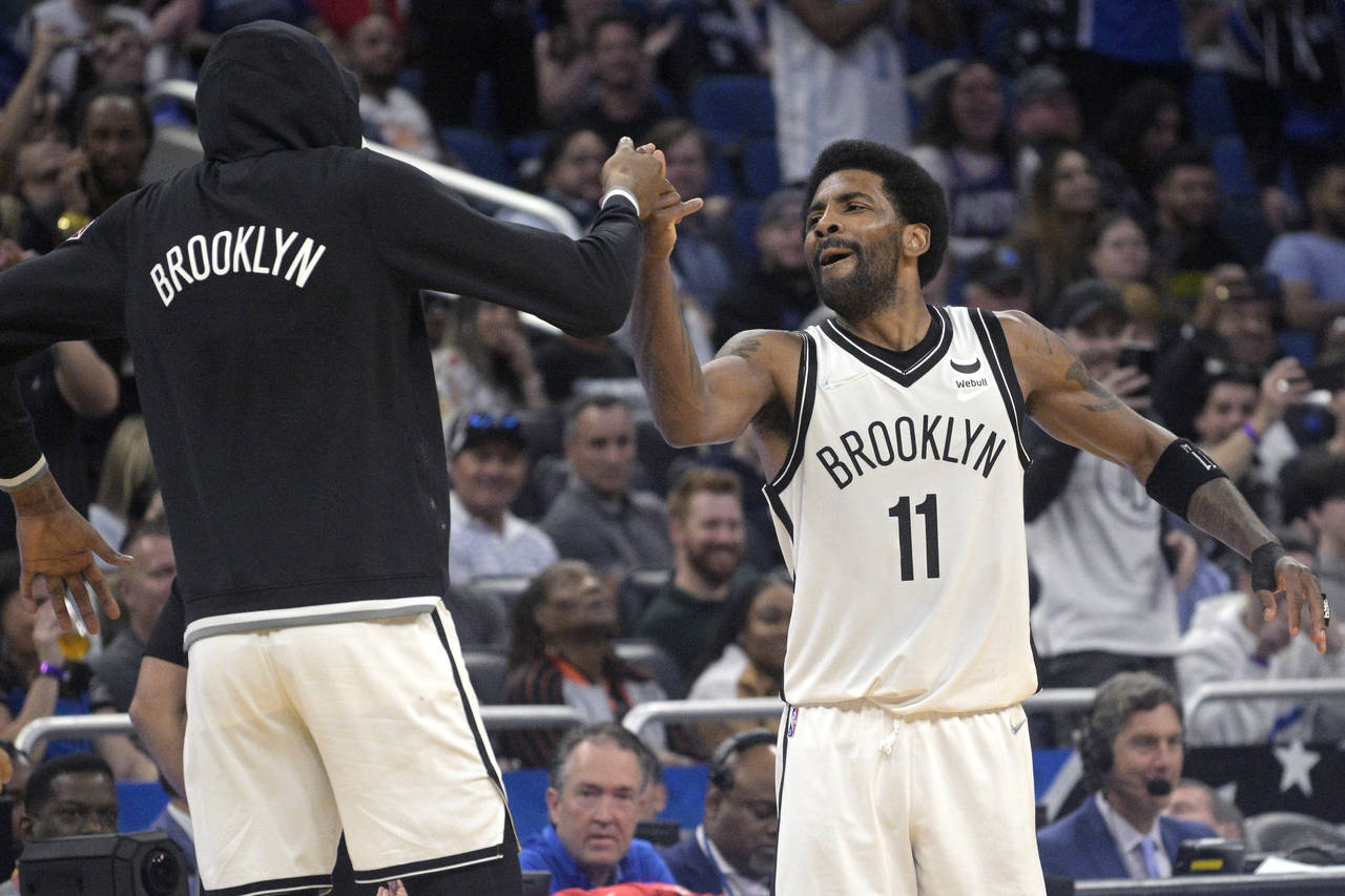 Brooklyn Nets guard Kyrie Irving (11) celebrates with forward Kevin Durant, left, after Irving scor...