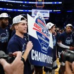 
              Villanova's Collin Gillespie celebrates with teammates while holding a sign after an NCAA college basketball game against Creighton in the final of the Big East conference tournament Saturday, March 12, 2022, in New York. (AP Photo/Frank Franklin II)
            
