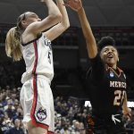 
              Connecticut's Paige Bueckers, left, shoots over Mercer's Shannon Titus, right, during the first half of a first-round women's college basketball game in the NCAA tournament, Saturday, March 19, 2022, in Storrs, Conn. (AP Photo/Jessica Hill)
            