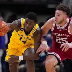
              Michigan forward Moussa Diabate (14) and Indiana forward Race Thompson (25) go for a loose ball in the second half of an NCAA college basketball game at the Big Ten Conference tournament in Indianapolis, Thursday, March 10, 2022. Indiana defeated Michigan 74-69. (AP Photo/Michael Conroy)
            