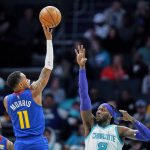 
              Denver Nuggets guard Monte Morris (11) shoots over Charlotte Hornets center Montrezl Harrell, right, during the first half of an NBA basketball game on Monday, March 28, 2022, in Charlotte, N.C. (AP Photo/Rusty Jones)
            