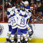 
              Buffalo Sabres players celebrate after  defeating the Calgary Flames in overtime NHL hockey game action in Calgary, Alberta, Friday, March 18, 2022. (Jeff McIntosh/The Canadian Press via AP)
            
