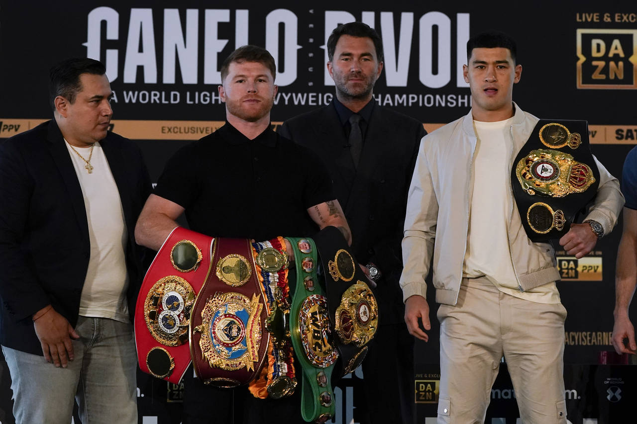 Canelo Alvarez, second from left, of Mexico, poses with Dmitry Bivol, right, of Russia, Wednesday, ...