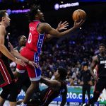 
              Philadelphia 76ers' Tyrese Maxey, center, goes up for a shot over Miami Heat's Kyle Lowry during the second half of an NBA basketball game, Monday, March 21, 2022, in Philadelphia. (AP Photo/Matt Slocum)
            