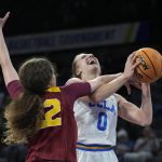 
              Southern California's Kyra White (22) fouls UCLA's Chantel Horvat (0) during the first half of an NCAA college basketball game in the first round of the Pac-12 women's tournament Wednesday, March 2, 2022, in Las Vegas. (AP Photo/John Locher)
            