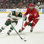 
              Minnesota Wild left wing Kevin Fiala (22) protects the puck from Detroit Red Wings center Michael Rasmussen (27) in the third period of an NHL hockey game Thursday, March 10, 2022, in Detroit. (AP Photo/Paul Sancya)
            