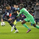 
              PSG's Kylian Mbappe, left, challenges for the ball with Saint-Etienne's Falaye Sacko during the French League One soccer match between Paris Saint Germain and Saint-Etienne at the Parc des Princes stadium in Paris, Saturday, Feb. 26, 2022. (AP Photo/Michel Euler)
            