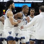 
              Villanova guard Justin Moore (5) is helped off the floor during the second half of a college basketball game against Houston in the Elite Eight round of the NCAA tournament on Saturday, March 26, 2022, in San Antonio. (AP Photo/David J. Phillip)
            