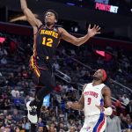 
              Atlanta Hawks forward De'Andre Hunter (12) dunks as Detroit Pistons forward Jerami Grant (9) defends during the second half of an NBA basketball game, Monday, March 7, 2022, in Detroit. (AP Photo/Carlos Osorio)
            