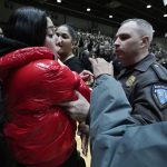 
              Police remove a fan from the court after an altercation stopped play during the second half of the Northeast Conference men's NCAA college basketball championship game between Bryant and Wagner, Tuesday, March 8, 2022, in Smithfield, R.I. (AP Photo/Charles Krupa)
            