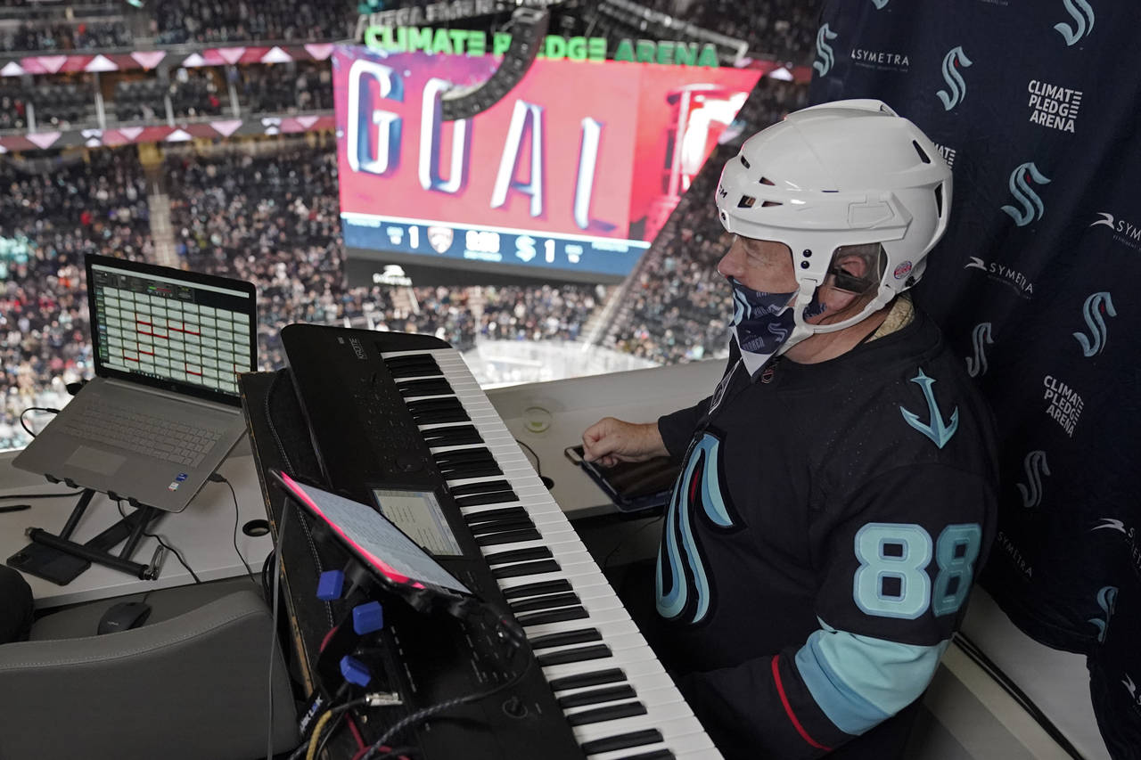 Seattle Kraken organist Rod Masters performs after a goal was scored during an NHL hockey game agai...