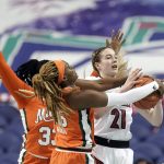
              Miami forwards Maeva Djaldi-Tabdi, left, and Naomi Mbandu (35) guard Louisville forward Emily Engstler (21) during the first half of an NCAA college basketball game in the quarterfinals of the Atlantic Coast Conference women's tournament in Greensboro, N.C., Friday, March 4, 2022. (AP Photo/Gerry Broome)
            