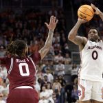 
              Auburn guard K.D. Johnson (0) shoots a 3-pointer over South Carolina guard James Reese V (0) during the second half of an NCAA college basketball game Saturday, March 5, 2022, in Auburn, Ala. (AP Photo/Butch Dill)
            