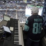 Seattle Kraken organist Rod Masters looks down to the ice at Climate Pledge Arena as he waits to preform during an NHL hockey game against the Florida Panthers, on Jan. 23, 2022, in Seattle. Masters played the role of the organist in "Slap Shot," the iconic 1977 hockey movie starring Paul Newman, and now he's now part of the fraternity of organists playing in arenas around the NHL. (AP Photo/Ted S. Warren)