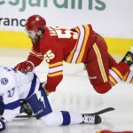 
              Calgary Flames' Noah Hanifin, right, falls onto Tampa Bay Lightning's Alex Killorm during the second period of an NHL hockey game Thursday, March 10, 2022, in Calgary, Alberta. (Larry MacDougal/The Canadian Press via AP)
            