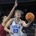 
              UCLA's Natalie Chou (23) shoots around Southern California's Tera Reed (3) during the first half of an NCAA college basketball game in the first round of the Pac-12 women's tournament Wednesday, March 2, 2022, in Las Vegas. (AP Photo/John Locher)
            
