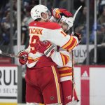 
              Calgary Flames left wing Matthew Tkachuk, left, congratuates left wing Johnny Gaudreau, who scored in overtime against the Colorado Avalanche in an NHL hockey game Saturday, March 5, 2022, in Denver. The Flames won 4-3. (AP Photo/David Zalubowski)
            