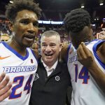 
              Boise State's Abu Kigab (24) and Emmanuel Akot (14) celebrates with coach Leon Rice following their victory over San Diego State in an NCAA college basketball game in the finals of Mountain West Conference men's tournament Saturday, March 12, 2022, in Las Vegas. (AP Photo/Rick Bowmer)
            