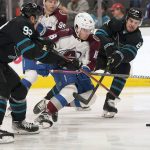 
              Colorado Avalanche center Alex Newhook, middle, skates toward the puck between San Jose Sharks left wing Rudolfs Balcers, left, and defenseman Jaycob Megna during the second period of an NHL hockey game in San Jose, Calif., Friday, March 18, 2022. (AP Photo/Jeff Chiu)
            