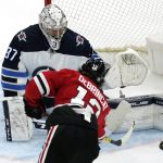 
              Winnipeg Jets goaltender Connor Hellebuyck saves a shot by Chicago Blackhawks left wing Alex DeBrincat during the second period of an NHL hockey game in Chicago, Sunday, March 20, 2022. (AP Photo/Nam Y. Huh)
            