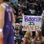 
              A fan holds up a sign in support of Phoenix Suns guard Devin Booker, front, late in the second half of the Suns' NBA basketball game against the Denver Nuggets on Thursday, March 24, 2022, in Denver. (AP Photo/David Zalubowski)
            