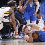 
              Dallas Mavericks guard Luka Doncic (77) hits the floor hard while chasing the loose ball against Utah Jazz guard Donovan Mitchell (45) during the first quarter of an NBA basketball game in Dallas, Sunday, March 27, 2022. (AP Photo/LM Otero)
            