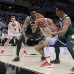 
              Wisconsin's Johnny Davis (1) is defended by Michigan State's Julius Marble II, third from right, and A.J. Hoggard (11) during the first half of an NCAA college basketball game at the Big Ten Conference tournament, Friday, March 11, 2022, in Indianapolis. (AP Photo/Darron Cummings)
            